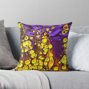 A neutral sofa with a brightly coloured throw pillow featuring rich shades of purple and yellow.
